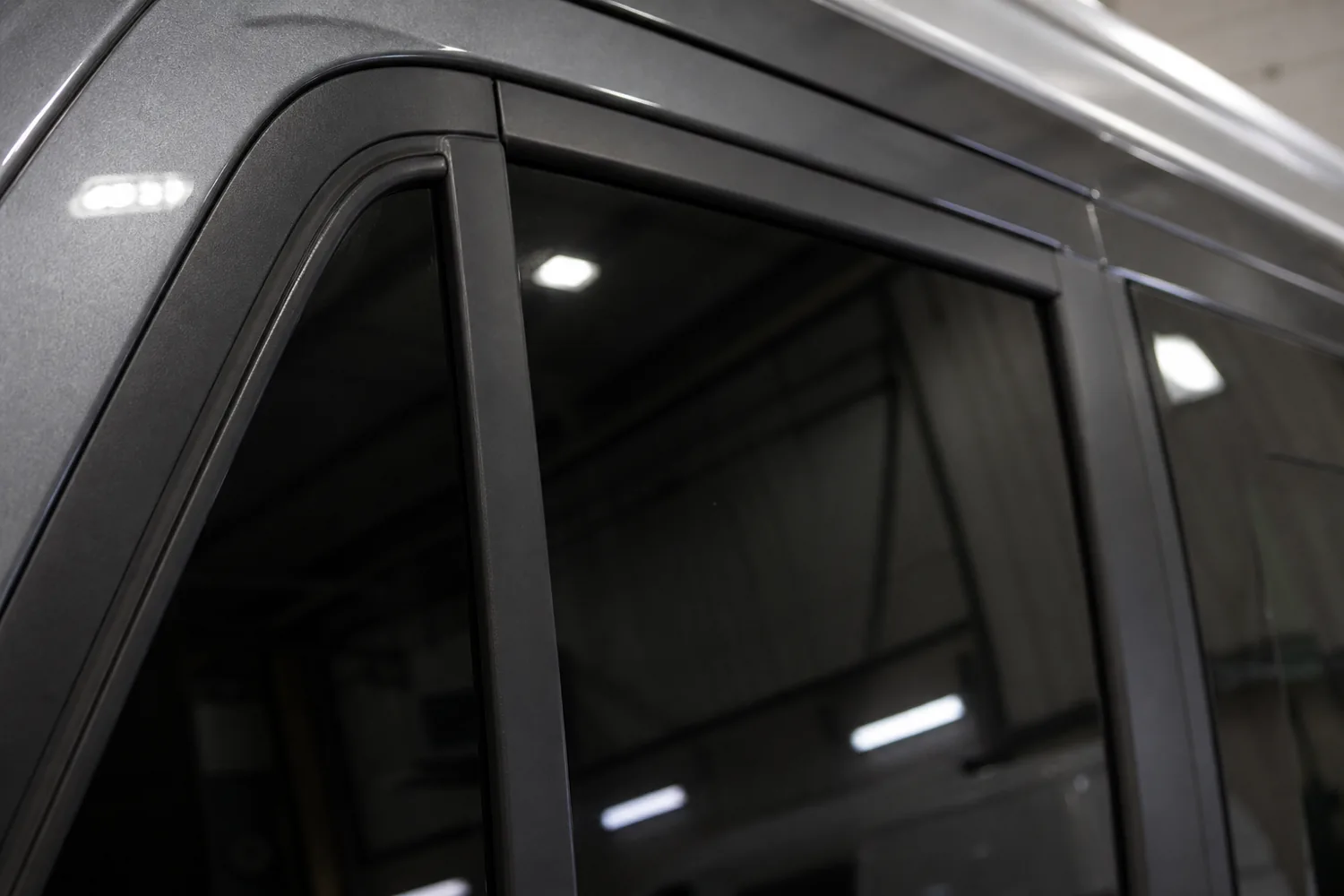 Satin black vinyl covering window surround trim after a chrome delete